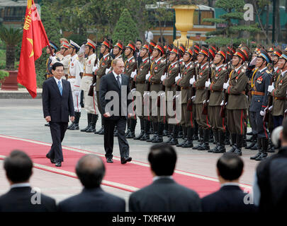 Der russische Präsident Wladimir Putin (C), begleitet von dem vietnamesischen Handelsminister Nguyen Minh Triet, kontrolliert die Ehrengarde bei der Begrüßungszeremonie im Präsidentenpalast in Hanoi am 20. November 2006. Putin führt eine große Delegation auf seinem offiziellen Besuch in Vietnam. (UPI Foto/Anatoli Zhdanov) Stockfoto