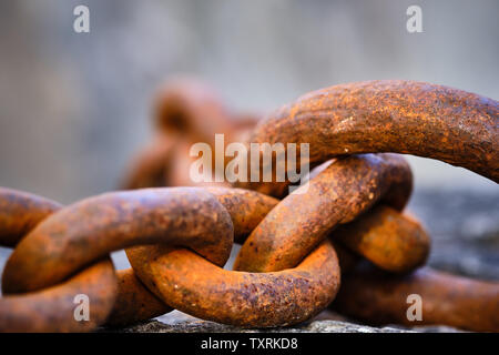 Rusty großen Ketten liegen auf einem Stein Stockfoto