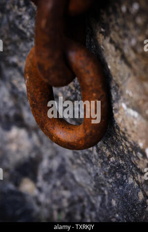 Eine große rostige Kette hängen von einem Stein Stockfoto