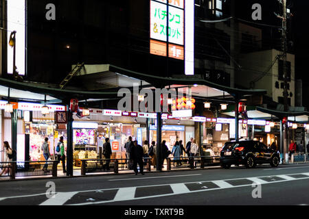 Kyoto, Japan - 16. April 2019: berühmte Einkaufspassage Street im Stadtteil Gion bei Nacht mit leuchtenden Lampen und Menschen zu Fuß auf dem Bürgersteig von Store Stockfoto