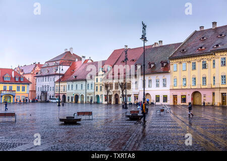 Sibiu, Rumänien - 27. März 2015: Häuser mit den berühmten Auge-geformten Windows auf den Dächern und den Menschen am Hauptplatz Stockfoto