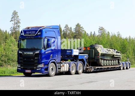 Orivesi, Finnland. Juni 6, 2019. Neue blaue Scania R650 Truck von Maavire mit Battle Tank auf flachen Anhänger auf Truck Stop Yard an einem sonnigen Tag im Sommer. Stockfoto