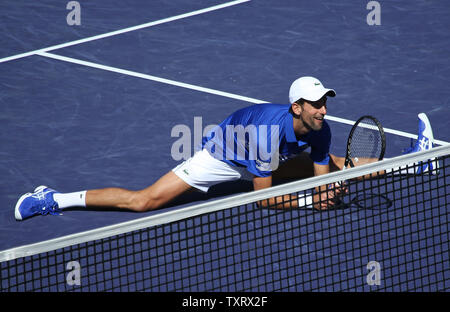 Novak Djokovic aus Serbien nicht die Splits während einer Ausstellung Gleichen am BNP Paribas Open in Indian Wells, Kalifornien am 16. März 2019. Die Ausstellung wurde organisiert nach der Annullierung der Halbfinale zwischen Roger Federer und Rafael Nadal Nadal aufgrund einer Knieverletzung passen. Foto von David Silpa/UPI Stockfoto