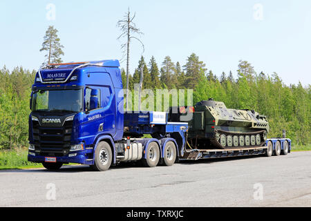 Orivesi, Finnland. Juni 6, 2019. Neue blaue Scania R650 Truck von Maavire mit Battle Tank auf flachen Anhänger auf Truck Stop Yard an einem sonnigen Tag im Sommer. Stockfoto