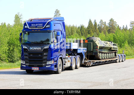 Orivesi, Finnland. Juni 6, 2019. Neue blaue Scania R650 Truck von Maavire mit Battle Tank auf flachen Anhänger auf Truck Stop Yard an einem sonnigen Tag im Sommer. Stockfoto