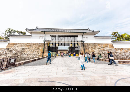 Kyoto, Japan - 17. April 2019: City street Weitwinkelaufnahme während morgen der Eintritt zum Schloss Nijo Schloss mit Menschen zu Fuß und Schutzvorrichtungen Stockfoto