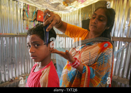 Shamim Begum, Mutter der indischen Muslime und 'Slumdog Millionaire' Kind Schauspieler Mohammed Azharuddin Ismail Kämme sein Kind Haar in einem Slum in Osten Bandra in Mumbai, Indien am 16. März 2009. (UPI Foto/Mohammad Kheirkhah) Stockfoto