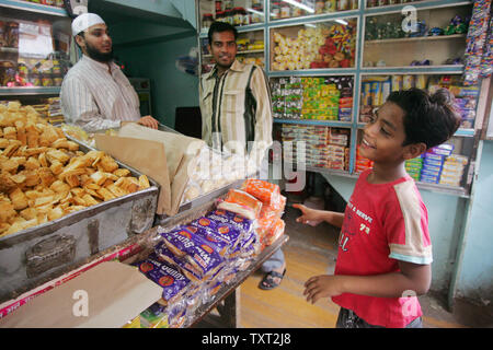 Indische Muslime und 'Slumdog Millionaire' Kind Schauspieler Mohammed Azharuddin Ismail (R) bittet um eine Schokolade in ein Geschäft im Osten Bandra in Mumbai, Indien am 16. März 2009. (UPI Foto/Mohammad Kheirkhah) Stockfoto