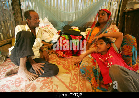 Indische Muslime und 'Slumdog Millionaire' Kind Schauspieler Mohammed Azharuddin Ismail (R) mit seinem Vater Mohammed Ismail (L) und seine Mutter Shamim Begum einen Rest in ihrem Slum in Ost Bandra in Mumbai, Indien, 16. März 2009. (UPI Foto/Mohammad Kheirkhah) Stockfoto