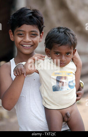 Indische Muslime und 'Slumdog Millionaire' Kind Schauspieler Mohammed Azharuddin Ismail hält ein Baby mit einem Bild von Bollywood Schauspieler Amitabh Bachchan auf seinem T-Shirt in einem Slum in Ost Bandra in Mumbai, Indien am 16. März 2009. (UPI Foto/Mohammad Kheirkhah) Stockfoto