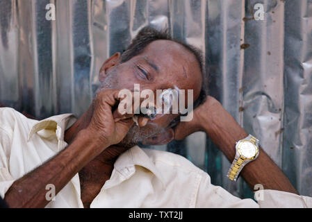 Mohammed Ismail, Vater der indischen Muslime und 'Slumdog Millionaire' Kind Schauspieler Mohammed Azharuddin Ismail (nicht gesehen) raucht in einem Slum in Ost Bandra in Mumbai, Indien am 16. März 2009. (UPI Foto/Mohammad Kheirkhah) Stockfoto