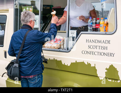 Die Burg Stirling, Stirling, Perthshire, Schottland, Vereinigtes Königreich, 25. Juni 2019. UK Wetter: ein reifer Mann kauft ein Eis von den luxuriösen Molkerei ice cream van auf der Castle Esplanade Stockfoto