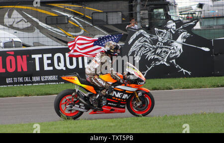 Amerikanische Colin Edwards verzichtet auf die amerikanische Flagge während seiner Abkühlen. Runde nach der 7. Läuft der Red Bull Moto GP auf dem Indianapolis Motor Speedway am 10. August 2014 in Indianapolis, Indiana. UPI/Bill Coons Stockfoto