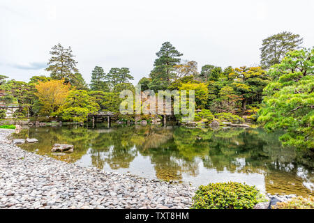 Kyoto, Japan Weitwinkelansicht Green Spring Garden im Imperial Palace Architektur mit Wasser Reflexion und Steine, Brücke am See Teich Stockfoto