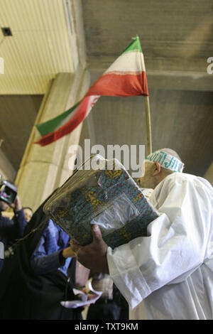 Ali Akbar Nassiri Khansari, trug eine Schärpe, hat Heilige Koran in einer Hand & des Iran Flagge in der anderen Hand, als er registriert einen Kandidaten für das Amt des Präsidenten des Iran in den ersten Tag der Registrierung beim Innenministerium in Teheran, 10. Mai 2005. Die iranischen Präsidentschaftswahlen stattfinden wird am 17. Juni. (UPI Foto/Mohammad Rezaei) Stockfoto