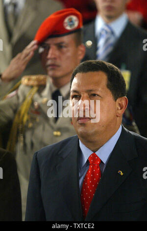 Venezuelas Präsident Hugo Chavez hört die Nationalhymnen der beiden Länder als Soldat grüßt, während einer Zeremonie, die der ersten Klasse um die islamische Republik zu Chavez an der Universität Teheran, in Teheran, Iran, der am 30. Juli 2006. (UPI Foto/Mohammad Kheirkhah) Stockfoto