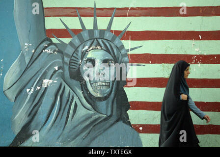 Eine iranische Frau passiert vor wandbild - bedeckte Wand voller Gemälde der amerikanischen Freiheitsstatue malte auf der Wand des alten US-Botschaft in Teheran, Iran am 25. September 2007. (UPI Foto/Mohammad Kheirkhah) Stockfoto