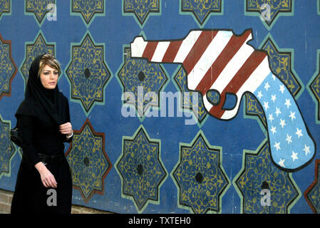 Eine iranische Frau passiert vor wandbild - bedeckte Wand voller Gemälde der amerikanischen Freiheitsstatue malte auf der Wand des alten US-Botschaft in Teheran, Iran am 25. September 2007. (UPI Foto/Mohammad Kheirkhah) Stockfoto