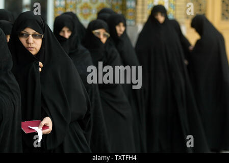 Iranische Frauen halten Sie Ihre Zertifikate, wie sie in Zeile vor ihre Stimmabgabe für das iranische Parlament im Wahllokal im Saint Masoumeh Heiligtum in der heiligen Stadt Qom, 80 Meilen (130 Kilometer) südlich von Teheran, Iran am 14. März 2008. (UPI Foto/Mohammad Kheirkhah) Stockfoto