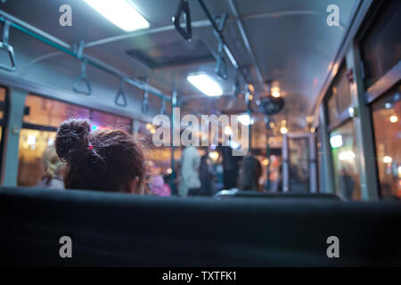 Leute sitzen auf einem komfortablen Bus in selektiven Fokus und verschwommenen Hintergrund. s Das Mass Transit Passagiere im Bus. Menschen in alten Bus Stockfoto