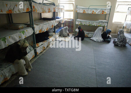 Datei Foto zeigt Iranischen gefangenen Frauen, die ihre Gesichter, wie sie in einem Zimmer während einer Tour für Journalisten des berüchtigten Evin Gefängnis in Teheran, Iran, am Juni 13, 2006 sitzen. Esha Momeni, 28, ein iranisch-amerikanische Studentin aus Los Angeles in Teheran inhaftiert ist und es ist nicht erlaubt, zu ihrer Familie zu sprechen, ihr Rechtsanwalt sagt. Momeni, beschrieben als Forscher in den Status von Frauen im Iran suchen, wurde für eine Verkehr Verletzung in Teheran am 15. Oktober gezogen und wird jetzt an den berüchtigten Evin Gefängnis gehalten. Momeni wurde ein Telefongespräch seit ihrer Verhaftung, die ihr erlaubt attor Stockfoto