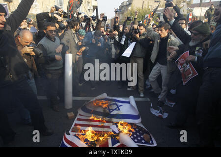 Iranische protestierenden Studenten brennen, israelischen, amerikanischen und britischen Flaggen während einer Demonstration vor der britischen Botschaft am 29. November, in Teheran, Iran, 2011. UPI/Maryam Rahmanian Stockfoto
