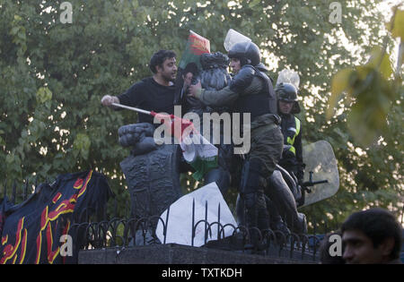 Iranische Studenten Klasse mit der Polizei, da Sie eine Wand während einer Demonstration in der Britischen Botschaft Teheran, Iran, Klettern am 29. November 2011. UPI/Maryam Rahmanian.. Stockfoto