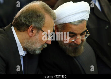 Diese offizielle Bild von Irans Oberster Führer Website zeigt der iranische Parlamentspräsident Ali Laridschani (L) im Gespräch mit Irans neuer Präsident Hassan Ruhani (R) während des Eid-al-Fitr Gebet an der Universität Teheran in Teheran, Iran, am 9. August 2013. Die Eid-al-Fitr Festival markiert das Ende des Heiligen muslimischen Fastenmonats Ramadan. UPI Stockfoto