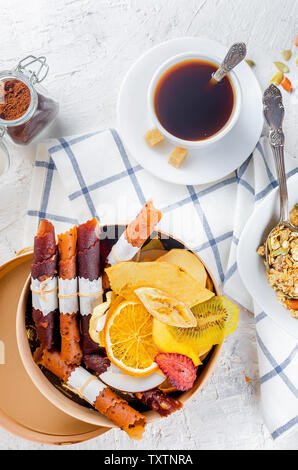 Viele verschiedene Früchte Chips und Obst leder Rollen in runder Holzbox auf weißem Holz- Hintergrund, Konzept der gesunden und richtigen Ernährung, Snack, Stockfoto