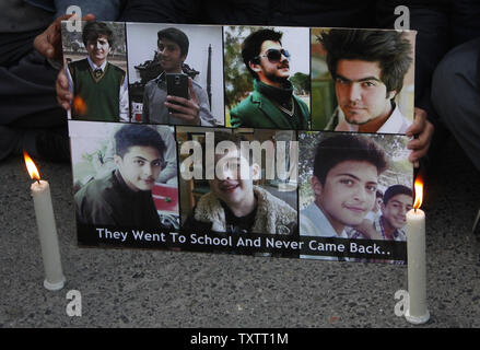 Pakistaner Kerzen an und halten Sie die Bilder der Kinder in der Peshawar Schule Angriff während einer Demonstration gegen die Taliban in Islamabad Ende am 17. Dezember 2014 getötet. Taliban Amokläufer tötete 141 Menschen, davon 132 Studenten waren, an einer militärischen Schule in Peshawar, Pakistan am 16. Dezember 2014. . UPI/Sajjad Ali Queshi Stockfoto