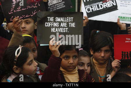 Pakistanische Waisenkind Kinder aus ÒSweet HomeÓ Kerzen an und halten Sie die Bilder der Kinder in der Peshawar Schule Angriff während einer Demonstration gegen die Taliban in Islamabad Ende am 17. Dezember 2014 getötet. Taliban Amokläufer tötete 141 Menschen, davon 132 Studenten waren, an einer militärischen Schule in Peshawar, Pakistan am 16. Dezember 2014. . UPI/Sajjad Ali Queshi Stockfoto