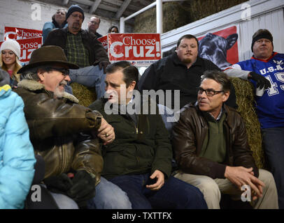 Texas Senator Ted Cruz, (C), 2016 der Republikanische Präsidentschaftskandidat, schüttelt Hände mit einem Unterstützer wie er sitzt mit ehemaligen Texas reg. Rick Perry (R), in der Sie warten bei einer Wahlkampfveranstaltung in einer Scheune zu gehorchen Hills Ranch, 26. Januar 2016, in Osceola, Iowa zu machen. Cruz läuft gegen einen großen Bereich der GOP Anwärter, einschließlich Immobilien Mogul Donald J. Trumpf, Florida sen Marco Rubio und pensionierte Neurochirurgen Ben Carson vor der ersten Iowa-in-der-nation Caucuses, 1. Februar. Foto von Mike Theiler/UPI Stockfoto