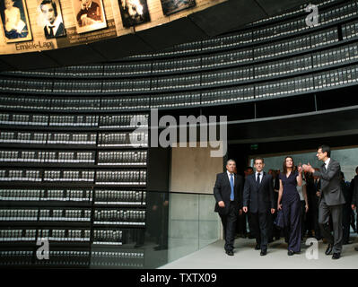 Carla Bruni Sorkozy Gesten, als sie und ihr Mann, der französische Präsident Nicolas Sarkozy (2, L) geben Sie die einzigartige "Halle der Namen" der Gedenkstätte Yad Vashem Museum in Jerusalem am 23. Juni 2008, von Avner Shalev (L), der Direktor von Yad Vashem, und Der israelische Präsident Shimon Peres (nicht gesehen) begleitet. Das Paar Durchläufe Hunderte von Bindemittel wwhcih Linie das Zimmer und beinhalten Dokumentation auf rund 3,5 Milli 0 auf der sechs Millionen Juden, die im Holocaust des Zweiten Weltkrieges umgekommen Der Raum enthält auch hunderte Foto von einzelnen Juden, die umgekommen sind, ein paar von denen links oben zu sehen sind, als Stockfoto