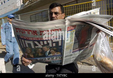 Ein israelischer liest eine Israelische newspapaer in Jerusalem mit der vorderen Seite Foto von US-Präsident George W. Bush und seine Familie letzte Nacht bei seiner Feier Rallye in Washington, DC nach dem Sieg über demokratische Kandidat Senator John Kerry in der US-Präsidentschaftswahl 2004, 4. November 2004. Fette Schlagzeilen in der Hebräischen erklären "Sieg" in Bezug auf Präsident Bushs Unterstützung für Israel. (UPI Foto/Debbie Hill) Stockfoto