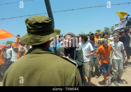 Ein israelischer Anti-ausrücken Demonstrant spricht mit den Soldaten durch einen Zaun in den südlichen Dorfes Kfar Maimon, 20. Juli 2005. Tausende von rechten Israelis wurden in Kfar Maimon durch die israelische Armee und Polizei angehalten, als sie versuchte, in Gusch Katif bis März die Siedler im Gazastreifen zu unterstützen. (UPI Foto/Debbie Hill) Stockfoto
