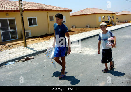 Jungen aus Nisanit israelischer Siedler im Gazastreifen, zu Fuß durch die neue Mobile home in Nitzan, im Süden Israels, 1. August 2005. Die vorübergehende Unterbringung wird von der Regierung für die israelischen Siedler, die vor der bevorstehenden Rückzug aus dem Gazastreifen zu bewegen möchten. Der israelische Premierminister Ariel Sharon sagte, dass über die Hälfte der in Frage kommenden Bewohner des Gazastreifens ausgefüllt haben Anwendungen, eine Entschädigung vom Rückzug Behörde zu erhalten. (UPI Foto/Debbie Hill) Stockfoto