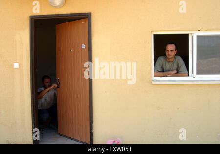 Ein israelischer Siedler aus Nisanit im Gazastreifen, schaut aus dem Fenster seiner neuen Mobilheim in Nitzan, im Süden Israels, 1. August 2005. Die vorübergehende Unterbringung wird von der Regierung für die israelischen Siedler, die vor der bevorstehenden Rückzug aus dem Gazastreifen zu bewegen möchten. Der israelische Premierminister Ariel Sharon sagte, dass über die Hälfte der in Frage kommenden Bewohner des Gazastreifens ausgefüllt haben Anwendungen, eine Entschädigung vom Rückzug Behörde zu erhalten. (UPI Foto/Debbie Hill) Stockfoto