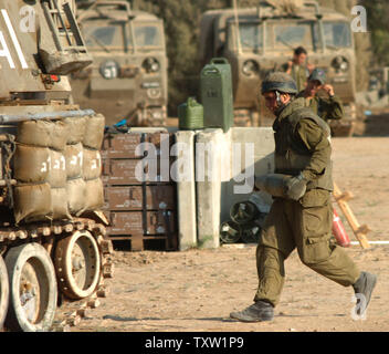 Ein IDF-Soldat trägt eine Shell zu einem mobilen Artillerie in Nahal Oz, Juli 05, 2006. Die israelische Armee versucht Palaestinian militanten versuchen Qasamrockets in Israel zu starten, zu schlagen. (UPI Foto/Joerg Waizmann) Stockfoto