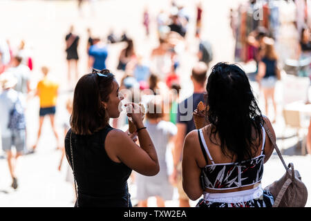 Siena, Italien - 27. August 2018: Zwei Frauen essen Eis gelato Kegel mit Löffeln auf italienischen Straßen in der alten Stadt Dorf in der Toskana Stockfoto