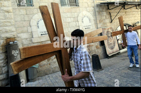 Eine palästinensische trägt Holzkreuze entlang der Via Dolorosa, des Leidensweges, am Karfreitag in die Altstadt von Jerusalem, 21. März 2008. (UPI Foto/Debbie Hill) Stockfoto