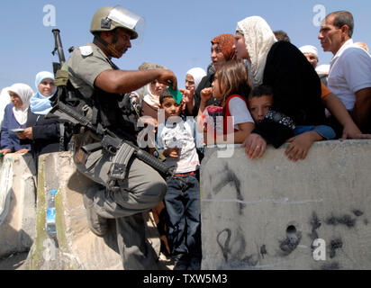 Israelische Grenzpolizisten prüfen Palästinensische Muslime warten die Kalandiya militärischen Checkpoint auf dem Weg an der Al zu beten für die Al-Aksa-Moschee in Jerusalem auf dem zweiten Freitag des muslimischen Fastenmonats Ramadan, 12. September 2008. (UPI Foto/Debbie Hill) Stockfoto