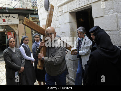 Eine christliche Pilger trägt ein Kreuz entlang der Via Dolorosa' der Weg des Leidens" am Karfreitag in der Altstadt von Jerusalem, 10. April 2009. Die Via Dolorosa wird geglaubt, der Weg, den Jesus ging, sein Kreuz trug, auf dem Weg nach Golgota und seine Kreuzigung. (UPI Foto/Debbie Hill) Stockfoto