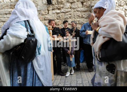 Orthodoxe Christen gehen von einem Mädchen mit einem Kreuz auf der Via Dolorosa, die traditionelle Art und Weise, dass Jesus sein Kreuz getragen, am Karfreitag in der Altstadt von Jerusalem, 2. April 2010. UPI/Debbie Hill Stockfoto