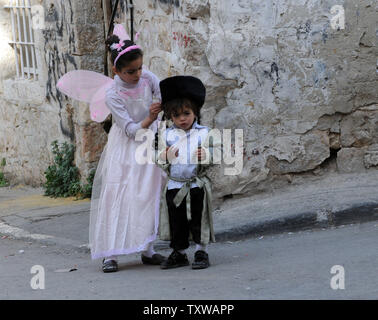 Ein Ultra-orthodoxen jüdischen Mädchen trägt ein Engel Kostüm während Festsetzung hat ein Junge an Purim in Mea Shearim in Jerusalem, 21. März 2011. Der jüdische Feiertag Purim feiert die Rettung der Juden aus Völkermord im alten Persien, wie im Buch Esther erzählt. UPI/Debbie Hill Stockfoto