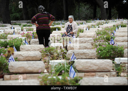 Israelische Frauen trauern um das Grab eines Verwandten vor Beginn der jährlichen Israelischen Memorial Tag am Mt. Herzl Soldatenfriedhof in Jerusalem, 8. Mai 2011. Israelis wird trauern 22,867 gefallenen Soldaten heute Abend, wenn Memorial Day mit dem Erklingen der eine Minute lang Sirene beginnt. UPI/Debbie Hill Stockfoto