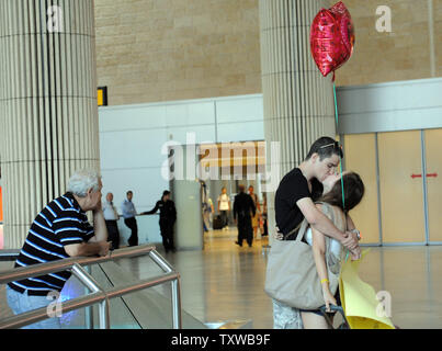 Die israelische Polizei sind hinter einer Israelischen paar Küssen in den internationalen Flughafen Ben Gurion in einem Vorgang zu stoppen pro-palästinensischen internationale Aktivisten in Israel eingesetzt, 8. Juli 2011. Mehr als 200 pro-palästinensischen Demonstranten versucht, Israel zu erreichen wurden an den Flughäfen in Europa gesperrt nach Israel ausländische Fluggesellschaften auf der schwarzen Liste gebeten, Reisende aus der Bordkarte Flüge zu stoppen. Die israelische Polizei nahm 30 Aktivisten, die in Israel UPI/Debbie Hill gelandet Stockfoto