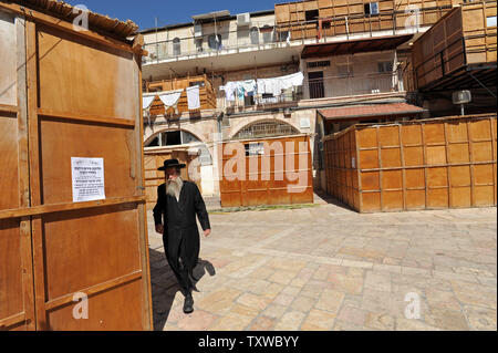 Eine ultra-orthodoxe jüdische Mann hinter einem hölzernen Laubhütte, die traditionellen stand, die während der Feier der Sukkot, das Laubhüttenfest, in Mea Shearim in Jerusalem, 10. Oktober 2011 verwendet wird. Die Sukkot Fest beginnt am 13. Oktober und erinnert an den Auszug der Juden aus Ägypten. UPI/Debbie Hill Stockfoto