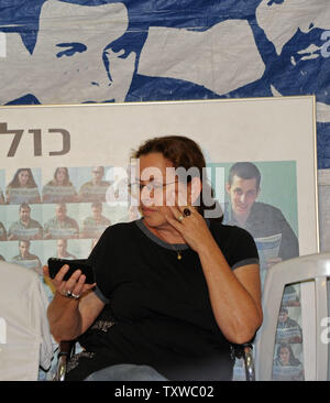 Aviva Schalit, die Mutter des gefangenen israelischen Soldaten Gilad Shalit, dessen Portrait im Hintergrund hängt, schaut Sie i-phone in einem Protest Zelt außerhalb der israelische Premierminister Benjamin Netanjahu in Jerusalem, 11. Oktober 2011 gesetzt. Israel und die Hamas ein Abkommen erreicht haben freien Shalit, die von der Hamas statt-Kämpfer in den Gazastreifen seit 25. Juni 2006, im Austausch für tausend palästinensische Gefangene, die Beamten, die auf beiden Seiten sagen. UPI/Debbie Hill Stockfoto