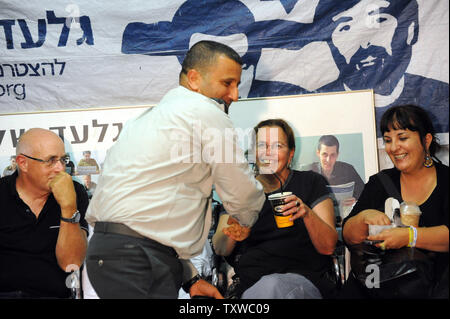 Aviva Schalit, die Mutter des gefangenen israelischen Soldaten Gilad Shalit, dessen Portrait im Hintergrund hängt, begrüßt einen Mitglied des israelischen Militärs in einem Protest Zelt außerhalb der israelische Premierminister Benjamin Netanjahu in Jerusalem, 11. Oktober 2011 gesetzt. Israel und die Hamas ein Abkommen erreicht haben freien Shalit, die von der Hamas statt-Kämpfer in den Gazastreifen seit 25. Juni 2006, im Austausch für tausend palästinensische Gefangene, die Beamten, die auf beiden Seiten sagen. UPI/Debbie Hill Stockfoto