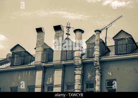 Aluminium Lüftung und Wärme Tabakpfeifen außerhalb der alten Industriegebäude. Schwarzweiß, Sepia vintage Hintergrund. Umweltverschmutzung und Ökologie Stockfoto